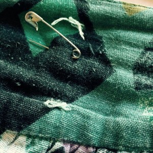 A safety pin has taken over the job of two buttons, whose attachments - that proved to be inadequate in the face of the wearer's exanding waist - are still visible